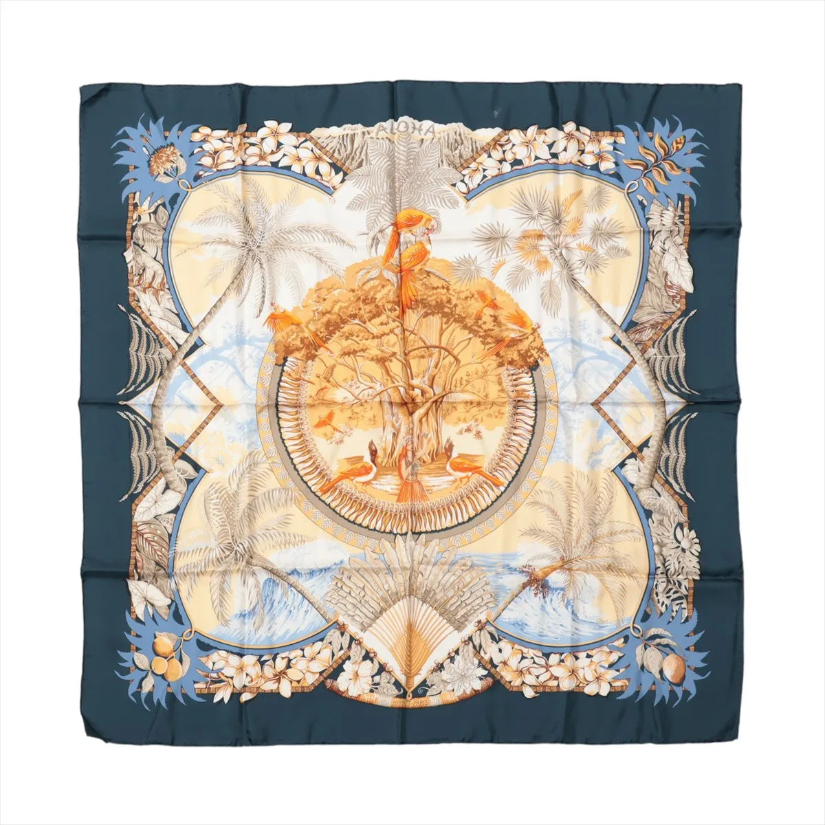 Hermès Carré 90 "Aloha" silk scarf in navy blue and beige featuring tropical birds perched in a large tree, surrounded by palm trees, ocean waves, coconuts, and floral patterns in a Hawaiian island-inspired design.