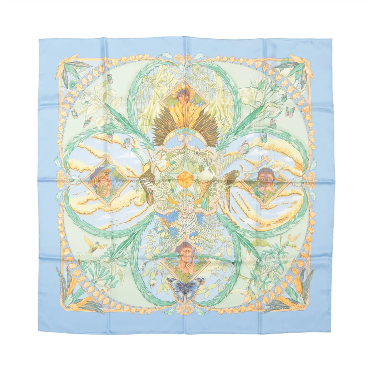 Hermès Carré 90 "Amazonia" silk handkerchief in blue, featuring intricate depictions of jungle foliage, birds, butterflies, a jaguar, and indigenous figures framed by golden botanical motifs, set against a soft sky-blue border for a rich tropical aesthetic.