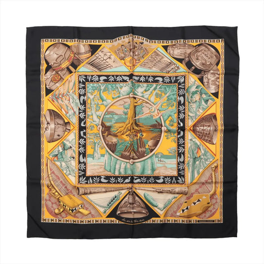 Hermès Carré 90 "Au Son du Tam Tam" silk handkerchief in black, featuring a vibrant tribal-inspired design with drums, musical instruments, and a central tree motif in yellow, turquoise, and earthy tones, bordered with geometric and symbolic patterns.