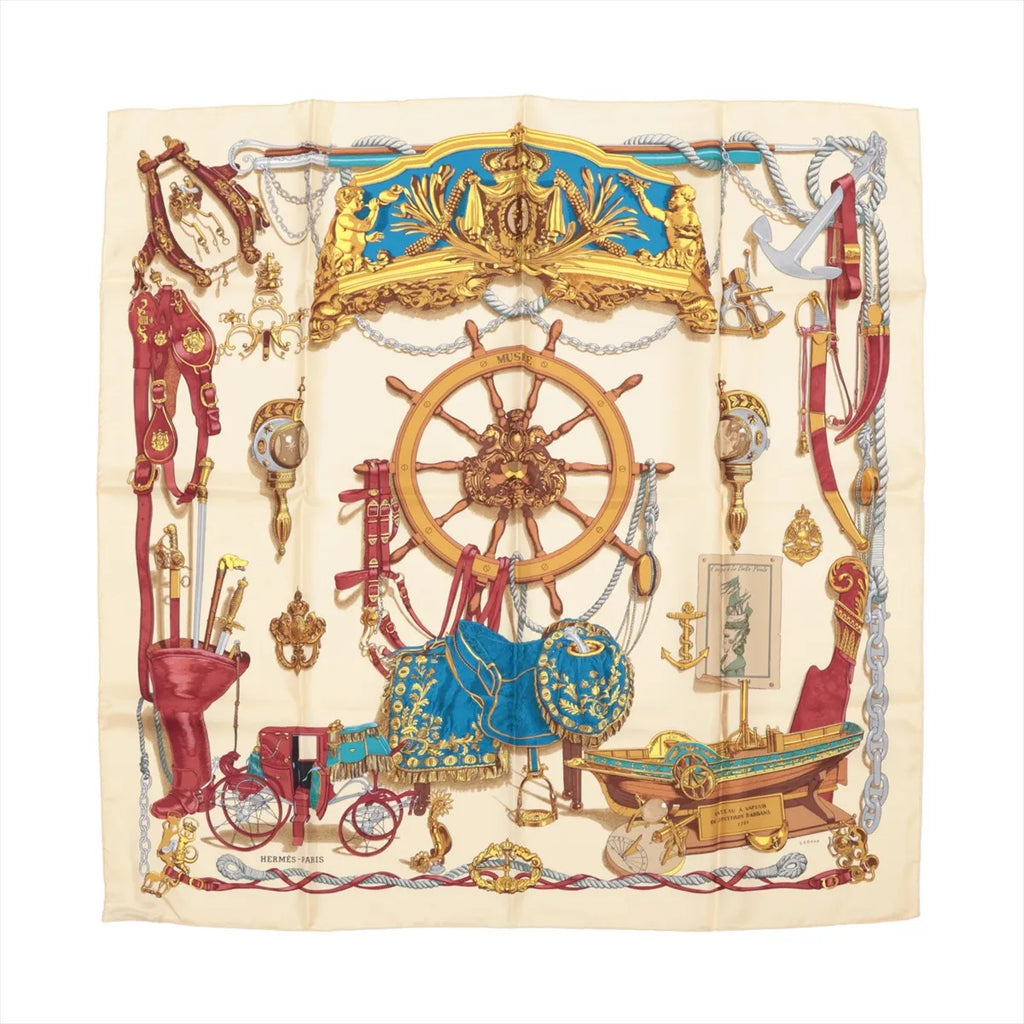 Hermès Carré 90 "Bateau à Vapeur de Jouffroy d’Abbans 1784" silk handkerchief in beige, featuring detailed illustrations of a ship's wheel, anchors, maritime tools, and decorative elements in red, gold, and blue, laid flat against a white background.