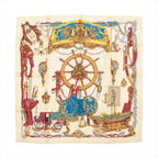 Hermès Carré 90 "Bateau à Vapeur de Jouffroy d’Abbans 1784" silk handkerchief in beige, featuring detailed illustrations of a ship's wheel, anchors, maritime tools, and decorative elements in red, gold, and blue, laid flat against a white background.