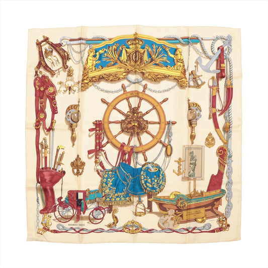 Hermès Carré 90 "Bateau à Vapeur de Jouffroy d’Abbans 1784" silk handkerchief in beige, featuring detailed illustrations of a ship's wheel, anchors, maritime tools, and decorative elements in red, gold, and blue, laid flat against a white background.