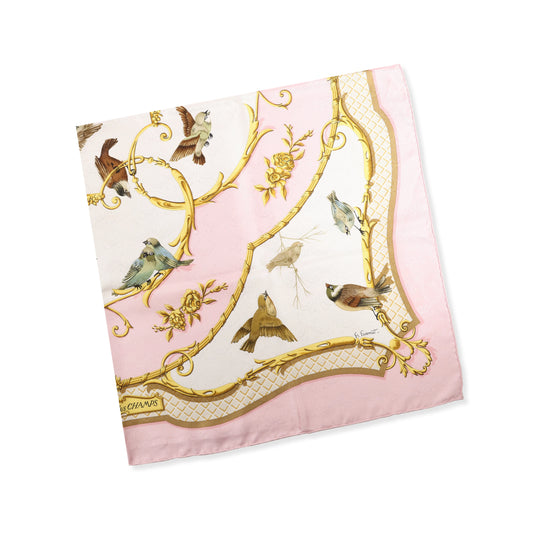 Hermès Carré 90 "La Clé des Champs" silk scarf featuring a pink and ivory background with gold scroll accents and various detailed birds in flight and perched throughout the design.