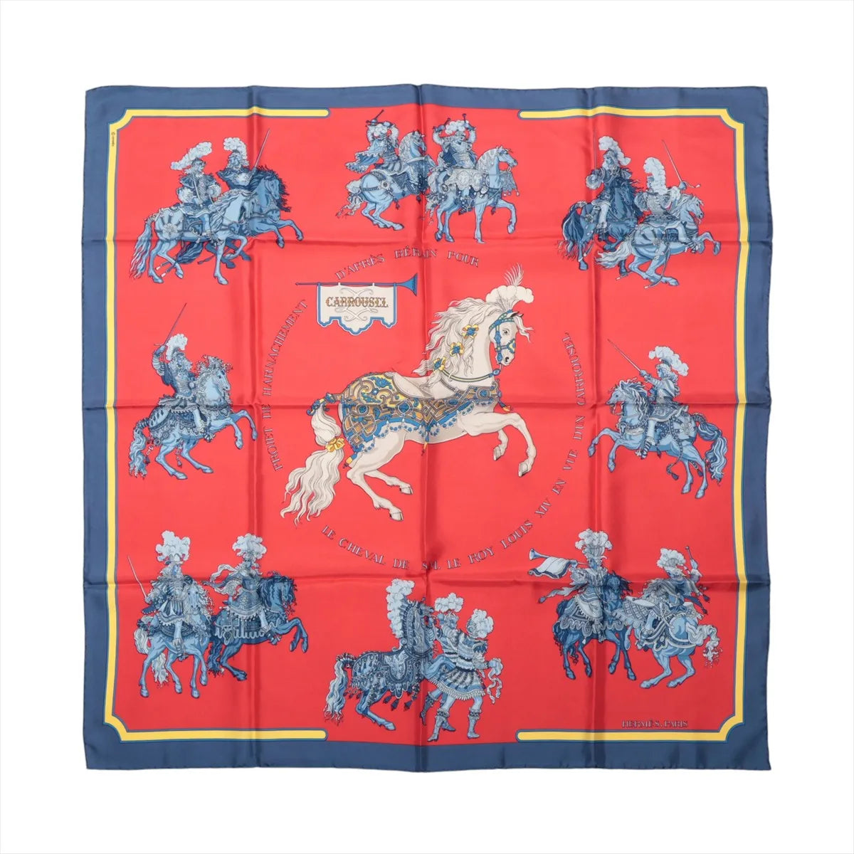Hermès Carré 90 Carrousel silk scarf in red with a navy border, central white horse and blue ceremonial riders.