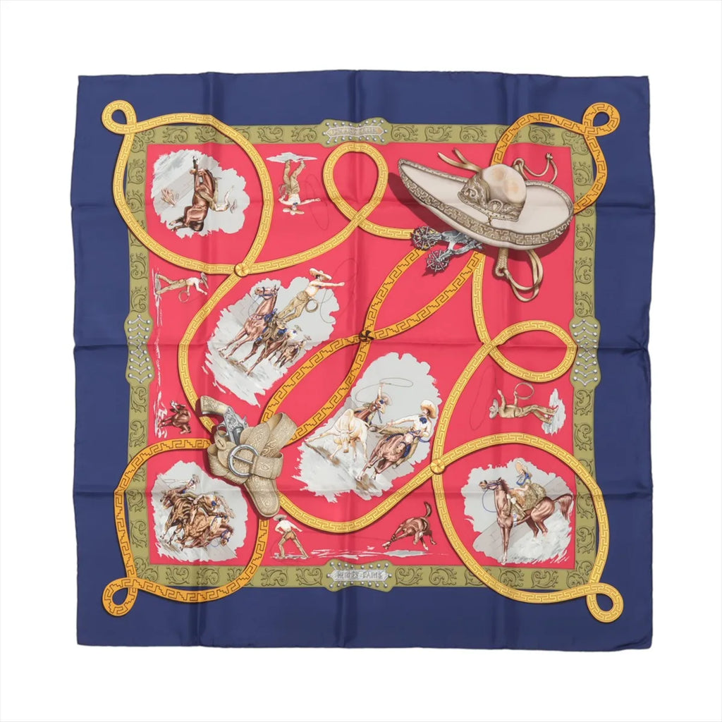 Hermès Carré 90 silk scarf in navy blue and red with gold lasso design, cowboy and horse illustrations, and green ornate border details.