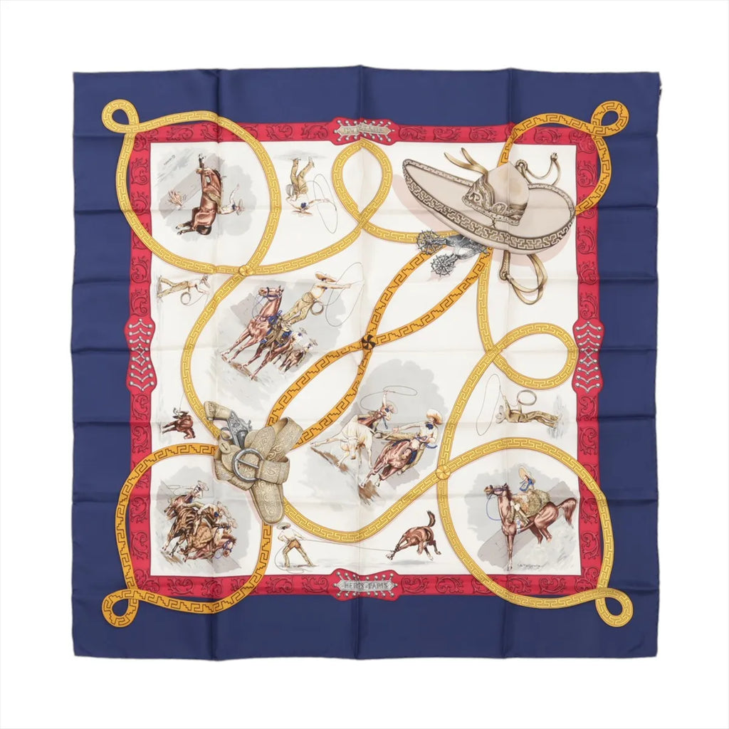 Hermès Carré 90 “Charreada” silk scarf with navy border, red frame, ivory center with rodeo rider scenes, and looping gold lariat motif.