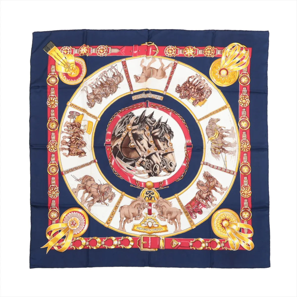 Hermès Carré 90 navy silk scarf with central horse head medallion, draft horse scenes, and red and gold belt-style border, laid flat