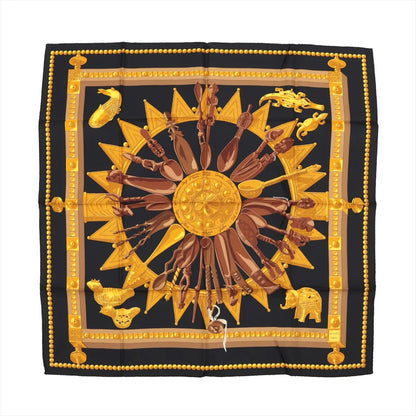 Hermès Carré 90 "Cuillers d’Afrique" silk scarf in black with golden and brown African spoon and sunburst motif framed by a dotted border.