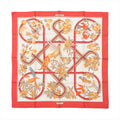 Hermès Carré 90 “Caraïbes” silk scarf with red border, ivory center, ribbon-style lines, and illustrated birds and flowers in warm tones.