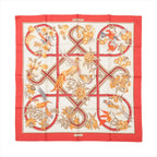 Hermès Carré 90 “Caraïbes” silk scarf with red border, ivory center, ribbon-style lines, and illustrated birds and flowers in warm tones.