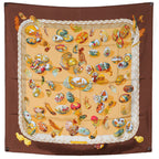 Hermès Carré 90 "Couvée d’Hermès" double-pleated silk handkerchief in brown, featuring a diamond-shaped silhouette with multicolored illustrations of birds and feathers on a warm beige background, framed by layered pleated edges.