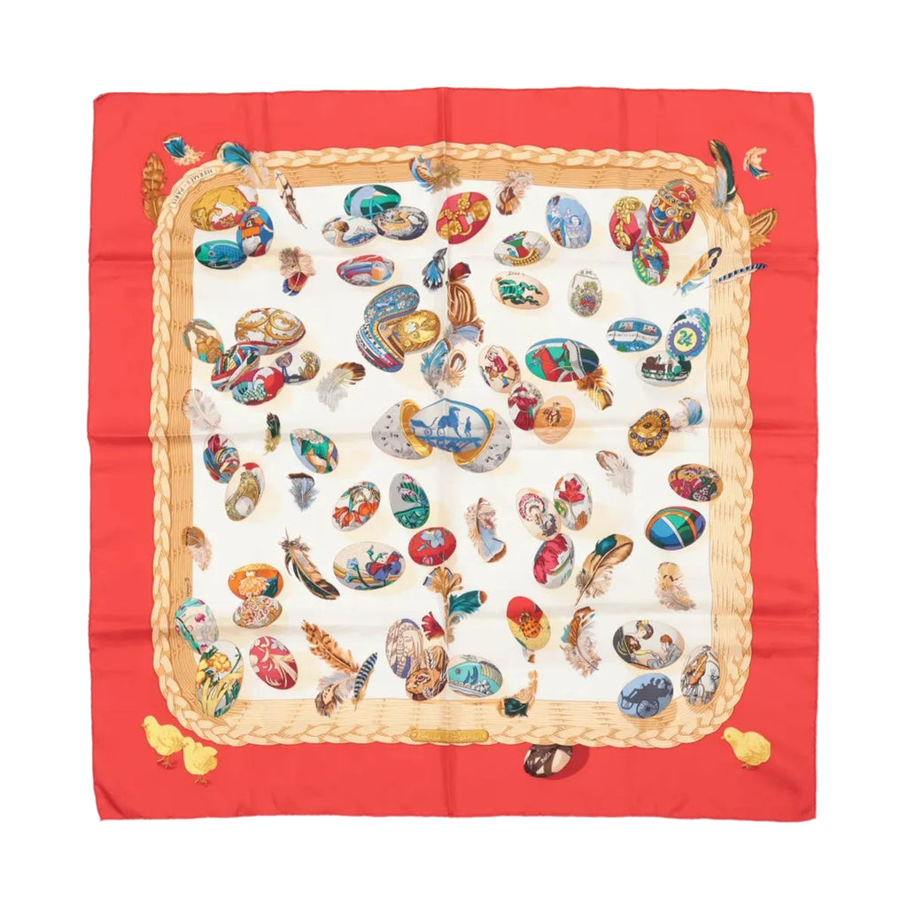 Hermès Carré 90 silk scarf with red border, cream center, colorful egg illustrations and scattered feathers, framed by a braided rope motif on white background