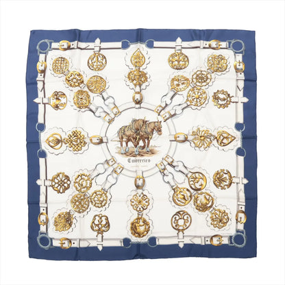 Hermès Carré 90 "Cuivreries" silk scarf in navy blue and white, featuring a central image of two horses surrounded by ornate golden bridle hardware in a circular layout, bordered with belt and buckle motifs.