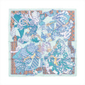 Hermès Carré 90 "Duels Oniriques" silk scarf in blue featuring four intricately illustrated armored knights in dynamic jousting poses, set against a mint green background with geometric and patterned borders in orange, white, and teal.