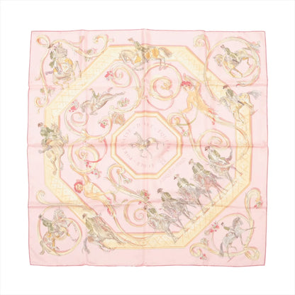 Hermès Carré 90 "École Portugaise d’Art Équestre" silk handkerchief in soft pink, illustrated with Portuguese horsemen and horses performing dressage, surrounded by ornate scrolls and floral accents, laid flat against a white background.