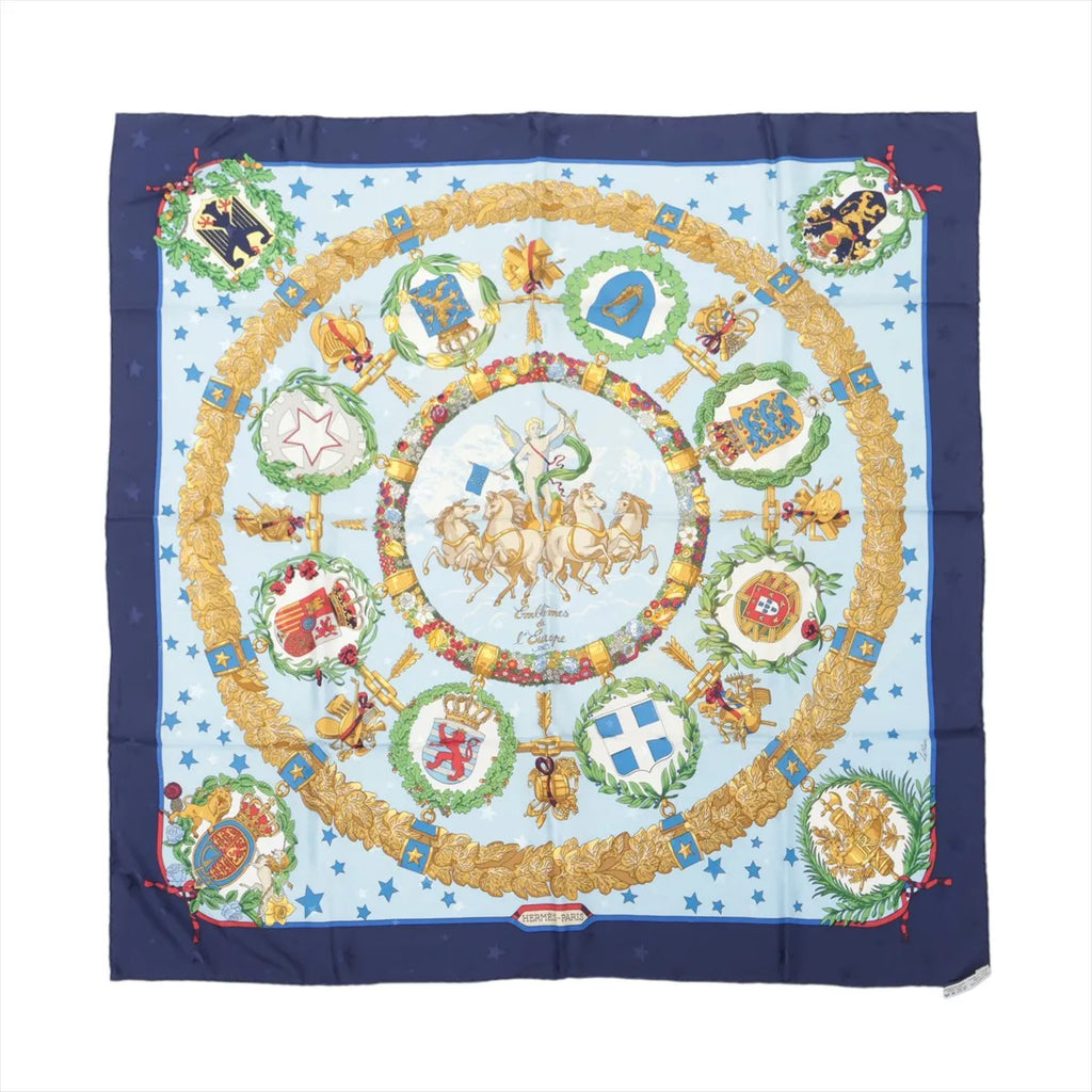Hermès Carré 90 navy and light blue silk scarf with gold laurel wreath border, star pattern, central chariot motif, and circular European emblem crests, laid flat