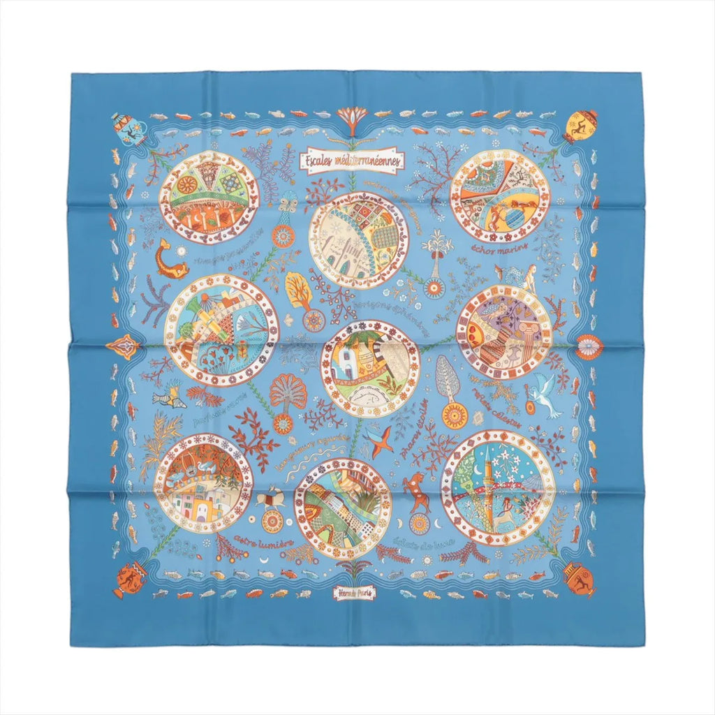 Blue Hermès Carré 90 silk scarf laid flat with multicolor Mediterranean-themed illustration in circular vignettes and a decorative border on a white background.