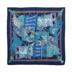 Hermès navy blue cashmere-silk scarf with layered turquoise, pale blue and white flags, ornate patterns and a striped rope border.