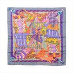 Hermès square scarf laid flat, with overlapping multicoloured banners, decorative motifs, a purple patterned frame and a grey outer border.