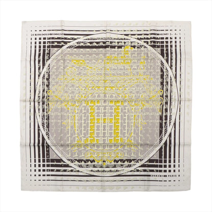 Hermès Carré 90 silk handkerchief featuring the "Faubourg Seconde" design in yellow, black, and white, with layered architectural motifs, grid lines, and an ornate central "H" emblem framed by a circular border.