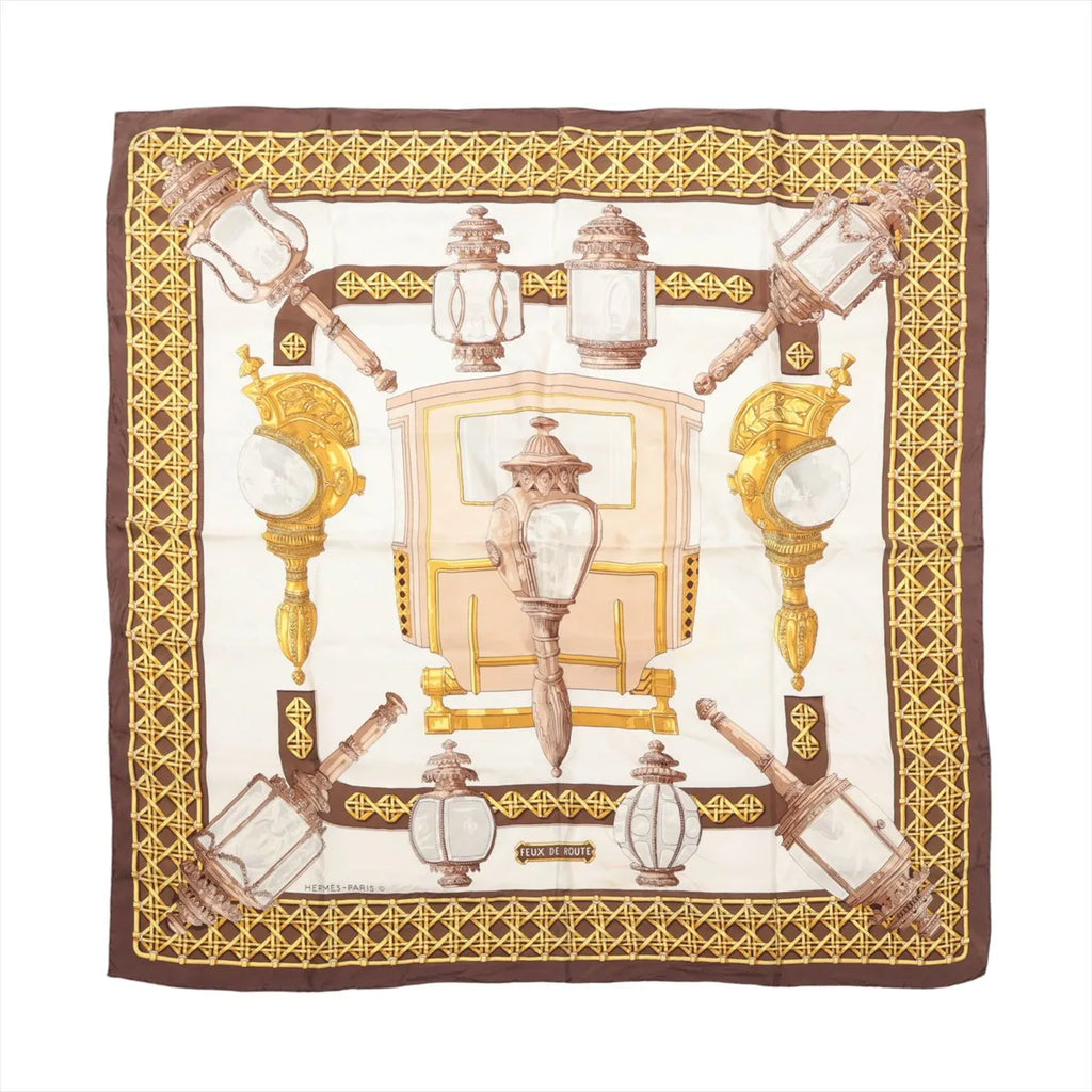 Hermès Carré 90 brown and ivory silk scarf with ornate carriage lanterns, gold lattice borders and a central horse-drawn coach motif.