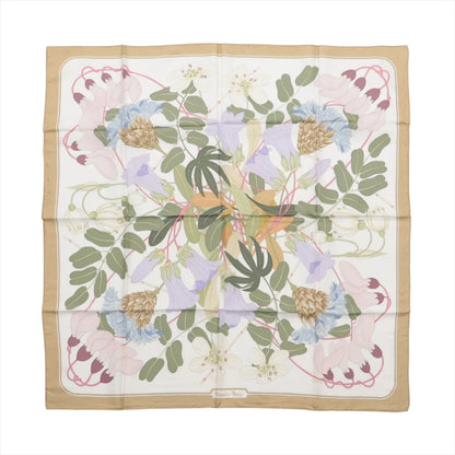 Hermès Carré 90 “Flora Graeca” silk scarf in beige with a white background, showcasing a soft pastel floral pattern including leaves, blossoms, and seed pods in a balanced, symmetrical layout.
