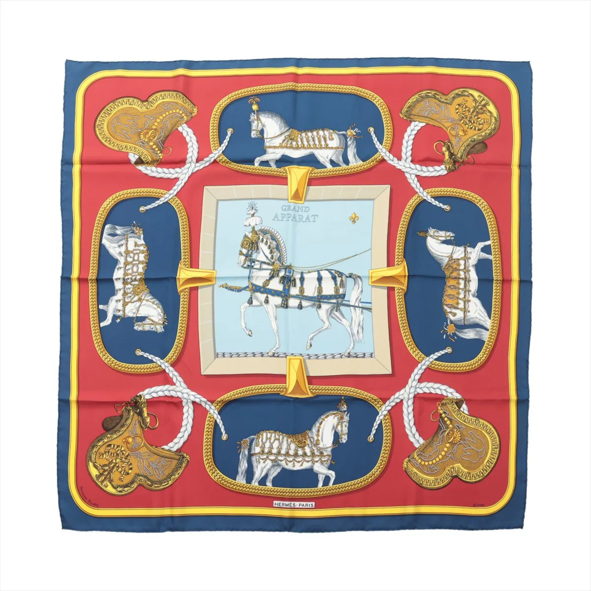 Hermès Carré 90 navy and red silk scarf with “Grand Apparat” horse and harness illustration, gold saddle motifs, braided rope details, and central framed horse design.