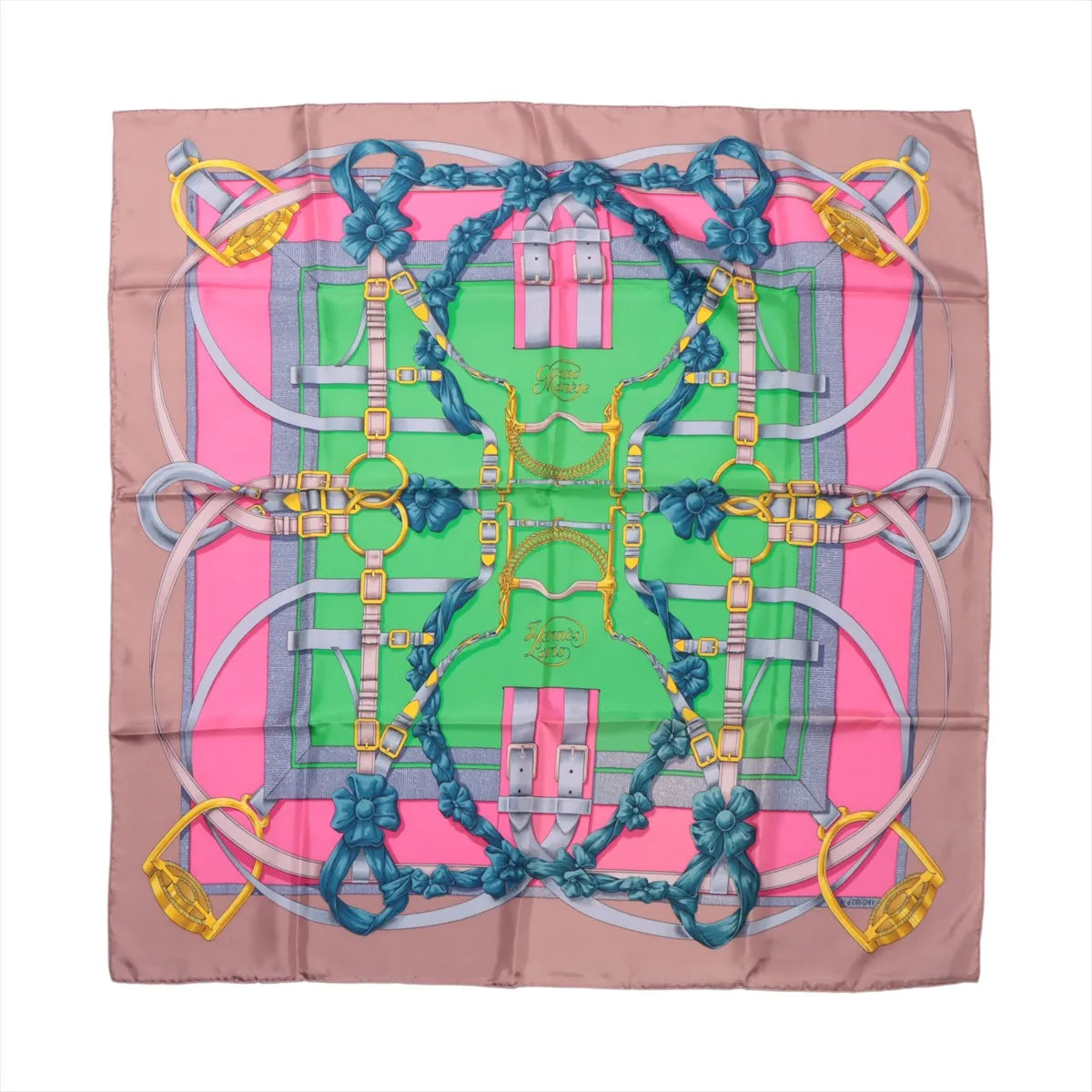 Flat-lay image of Hermès Carré 90 "Grand Manège" silk scarf featuring an equestrian motif in pink, green, taupe, and yellow with detailed bridles and stirrups.