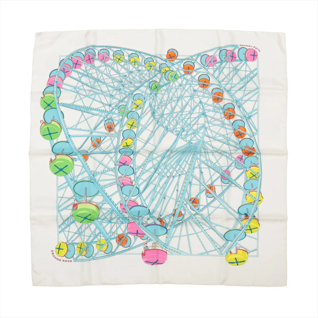 Hermès Carré 90 "Grande Roue" silk handkerchief in white and light blue, depicting a large Ferris wheel with pastel-colored gondolas in pink, green, yellow, orange, and blue, laid flat against a white background.