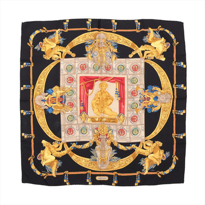 Hermès Carré 90 silk scarf titled "Hommage à Charles Garnier," featuring an ornate tribute to the Paris Opera architect with gold scrollwork, classical figures, and medallions surrounding a central statue, set on a black background with red and blue accents.