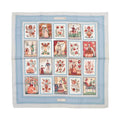 Hermès Carré 90 “Imagerie” silk scarf in light blue with pale blue border and grid of illustrated folk-style panels with flowers and figures.