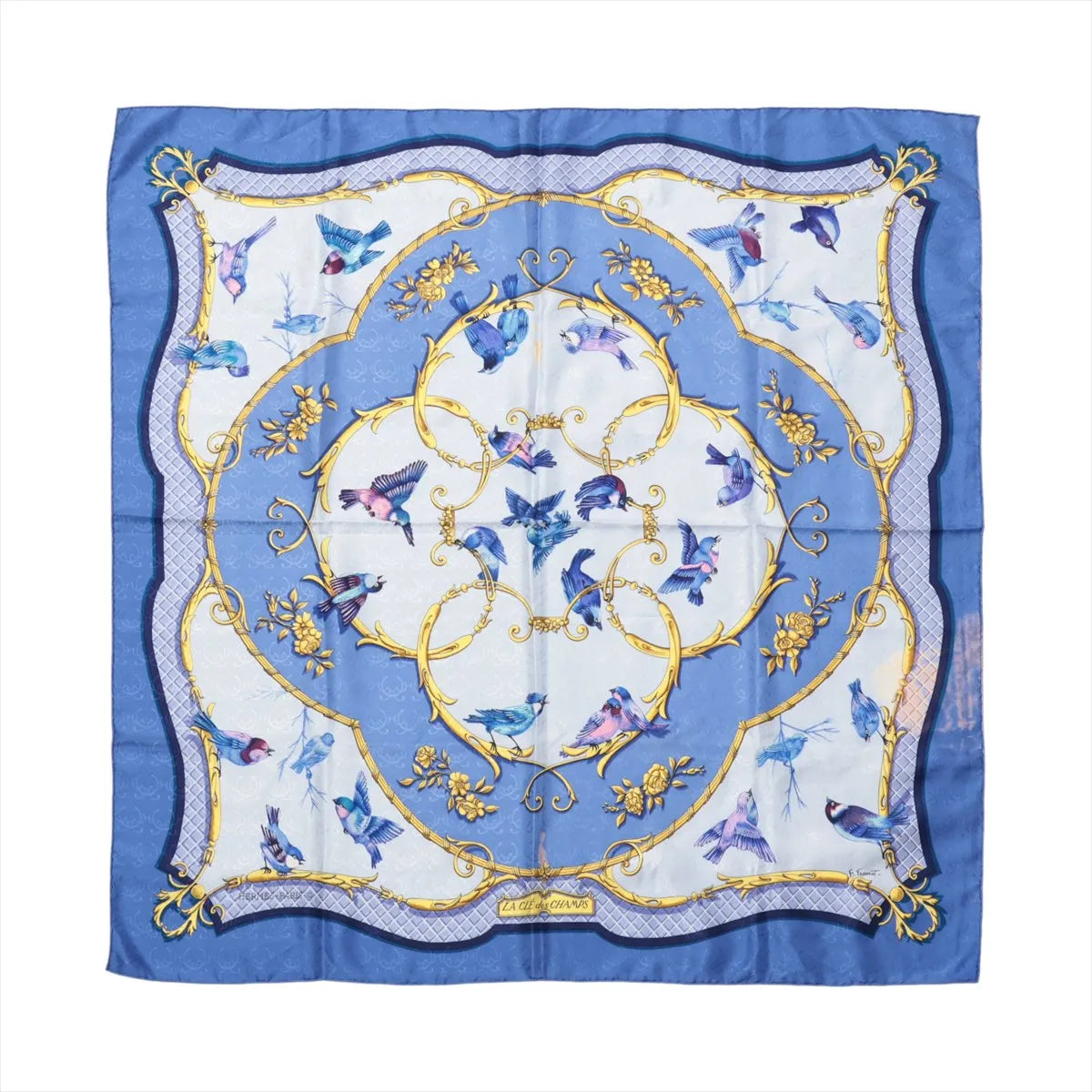 Hermès Carré 90 "La Clé des Champs" silk scarf in shades of blue featuring colorful birds in flight, ornate golden scrollwork, and a soft floral background framed by an elegant patterned border.