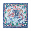 Hermès Carré 90 blue silk scarf with central elephant, giraffes, crocodiles, zebra, floral border, and multicolor wildlife motif on white background