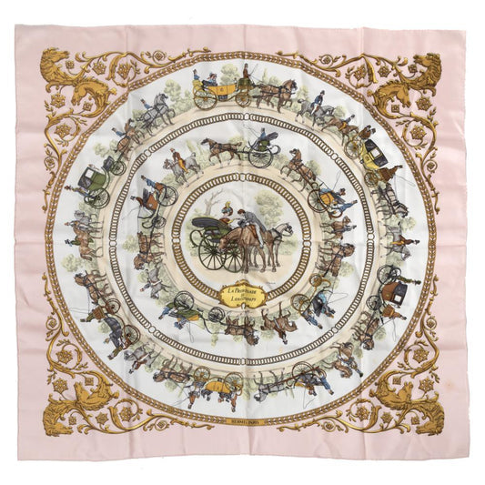 The Hermès Carré 90 “La Promenade de Longchamps” silk scarf in pink showcases an elegant equestrian carriage motif framed by ornate golden scrollwork. Luxurious and timeless, it’s perfect for collectors and style enthusiasts.
