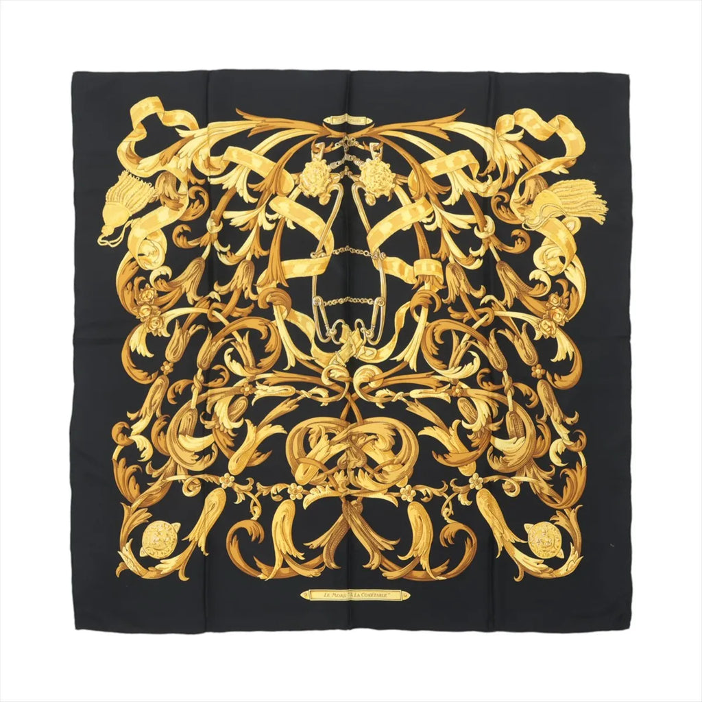 Hermès Carré 90 black silk scarf with ornate gold baroque scrollwork, tassel motifs, and central equestrian bit design on white background