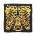 Hermès Carré 90 black silk scarf with ornate gold baroque scrollwork, tassel motifs, and central equestrian bit design on white background