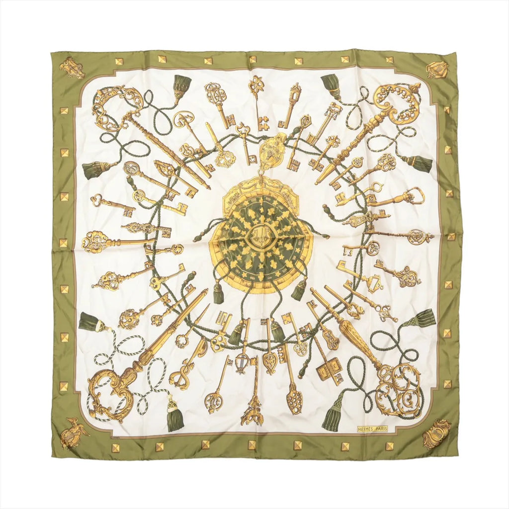 Hermès Carré 90 olive green and ivory silk scarf with ornate gold key motifs, green tassels, a central medallion and green border.