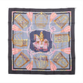 Gray Hermès Carré 90 silk scarf with ornate gold equestrian motifs, central horse and rider, pink tassels and dark navy border.