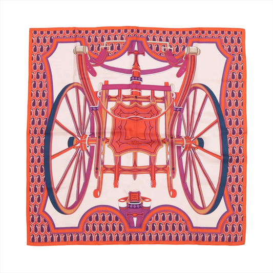 Hermès Carré 90 silk scarf in orange with a bold design of a decorative horse-drawn carriage and large wheels in pink, red, and purple on a light background.