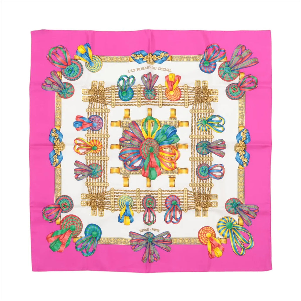 Hermès Carré 90 “Les Rubans du Cheval” silk scarf in pink with ivory center, ornate gold frame, and multicolor ribbon bow motifs.