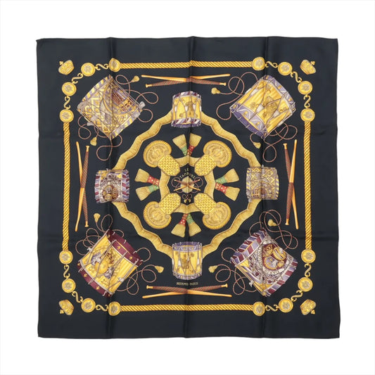 Hermès Carré 90 "Les Tambours" silk scarf in black featuring detailed illustrations of drums, tassels, ropes, and gold accents arranged in a symmetrical design with "Hermès-Paris" text.