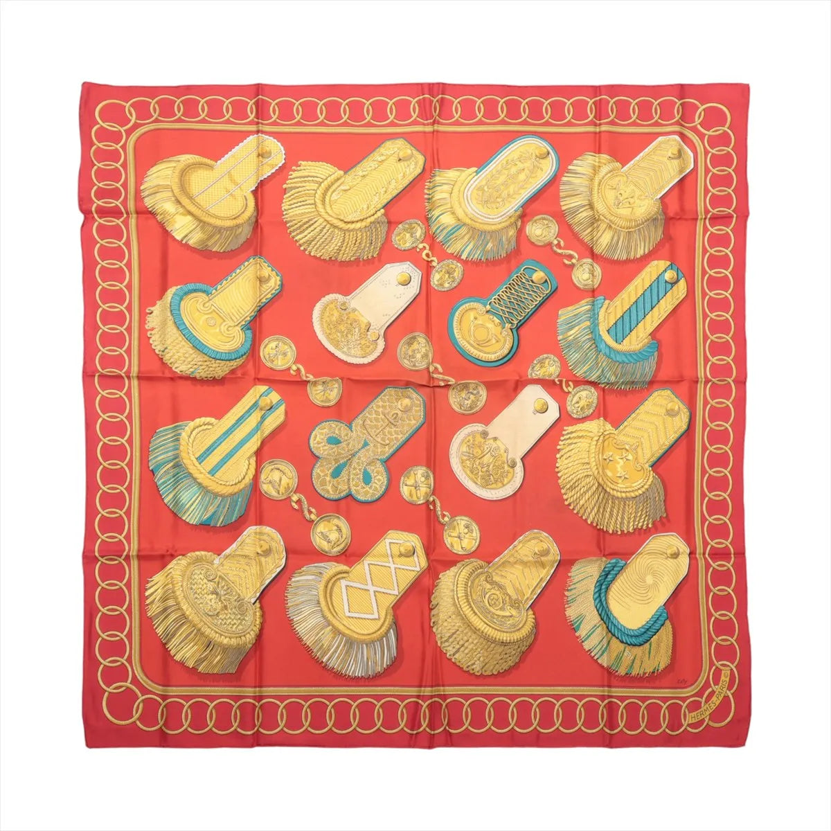 Flat view of a red Hermès Carré 90 silk scarf featuring gold military epaulettes, medallions, turquoise accents and a looping gold border.