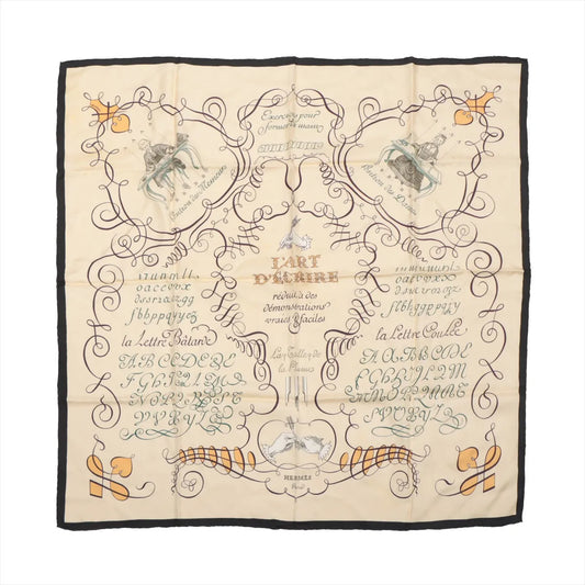 Hermès Carré 90 "L'ART D'ÉCRIRE" silk scarf in beige featuring intricate calligraphy-themed design, vintage-inspired motifs, and dark border detailing.