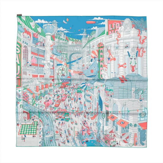 Hermès Carré 90 "Le Grand Prix du Faubourg" silk scarf in blue featuring a highly detailed and colorful Parisian cityscape with bustling crowds, storefronts, race cars, balloons, and whimsical illustrations.