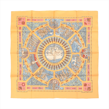 Top-down view of an Hermès Carré 90 "Le Songe de Poliphile" silk handkerchief in orange, featuring a detailed circular illustration with classical motifs in blue, red, and cream tones, bordered by geometric and symbolic artwork.