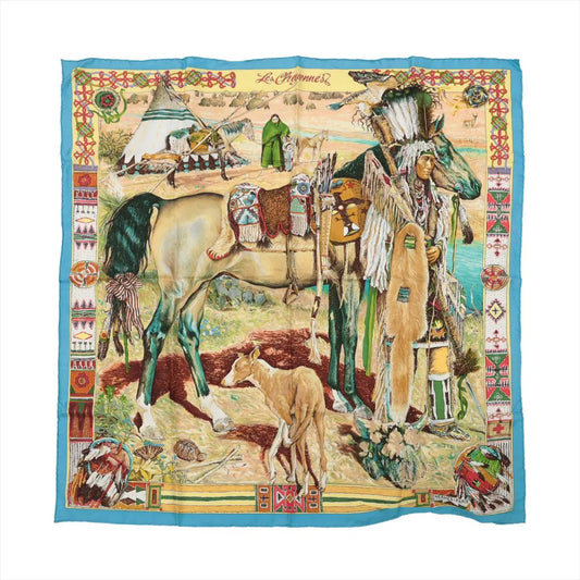Hermès Carré 90 “Les Cheyennes” silk scarf in beige and blue, showcasing a Native American chief, horse, and village scene with intricate tribal patterns and rich detailing.
