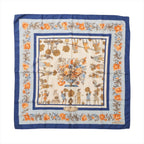 Blue Hermès Carré 90 silk scarf with orange floral border, illustrated garden figures and a large central flower arrangement.
