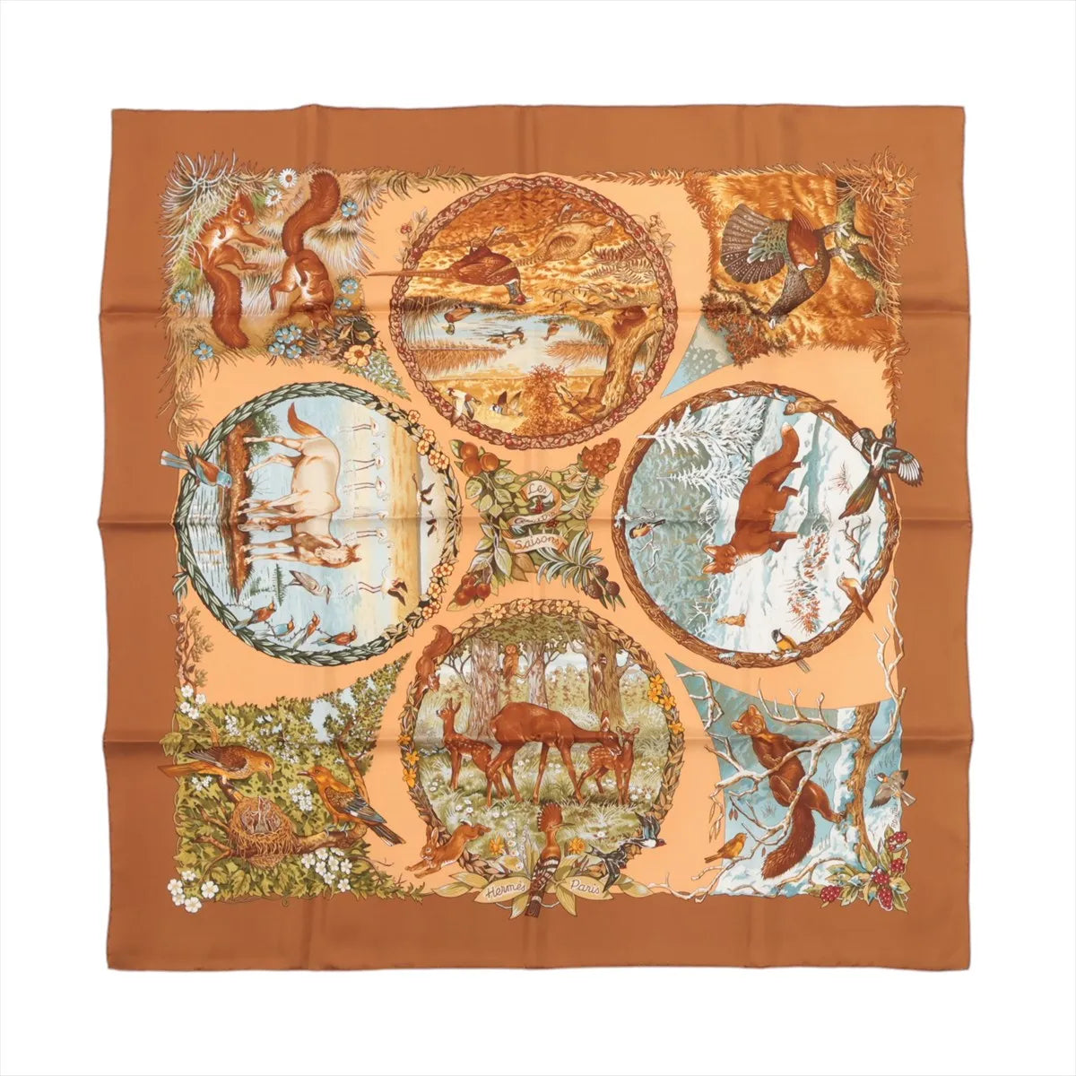Brown Hermès Carré 90 silk scarf laid flat with illustrated woodland animals and seasonal scenes in circular panels, framed by a brown border on white background.