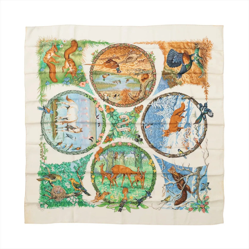 Ivory Hermès Carré 90 silk scarf with illustrated deer, birds, squirrels and seasonal woodland scenes in circular panels.