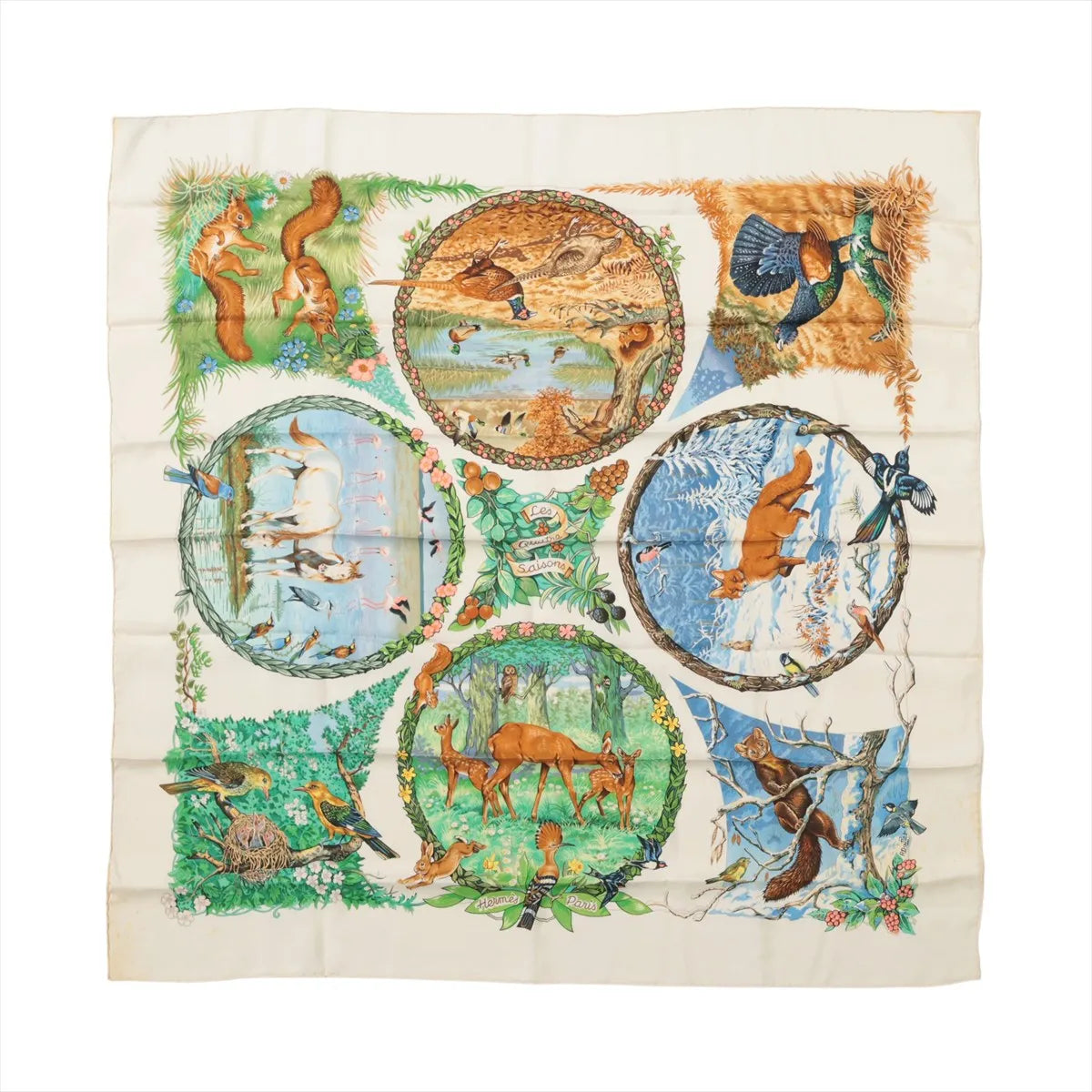 Ivory Hermès Carré 90 silk scarf with illustrated deer, birds, squirrels and seasonal woodland scenes in circular panels.